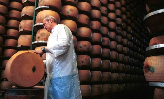 A consortium master checks the progress of the parmesan cheese for ageing in Parma, Italy.
