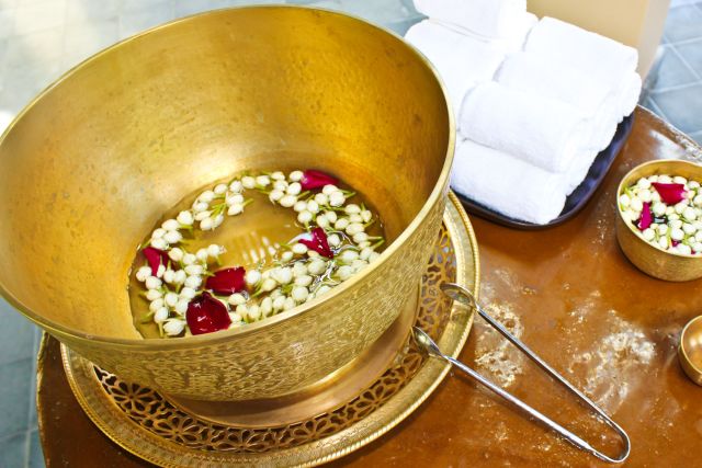 Alms bowl filled with lotus flower and rose petals.at Vana Bella, Thailand.