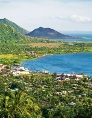Rabaul with the dark cone of Mt Tavurvur on the horizon.