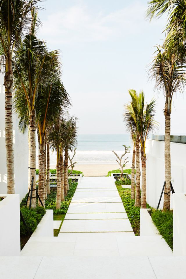 A path leads from the infinity pool to a wide beach at Alila Seminyak.