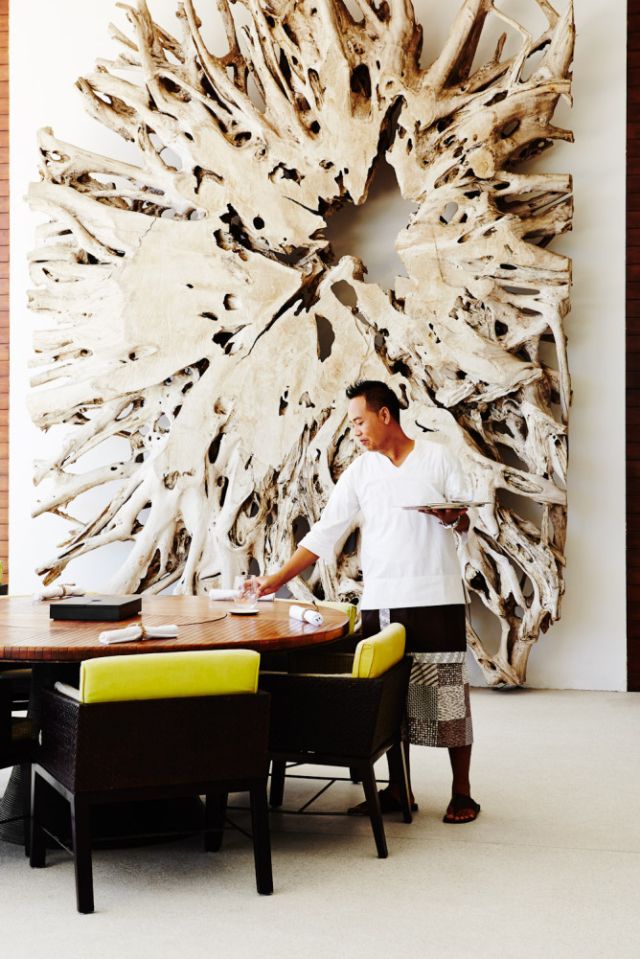 Alila Uluwatu’s Balinese restaurant with a stunning wall sculpture of reclaimed wood