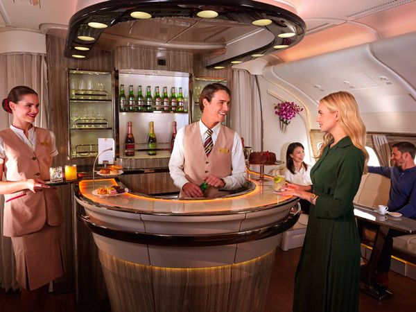 a passenger ordering a drink at the onboard lounge of Emirates A380