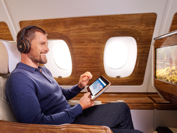 a man getting entertained with the ICE system onboard Emirates A380