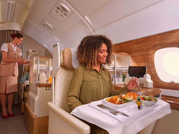 a woman enjoying a meal onboard Emirates A380