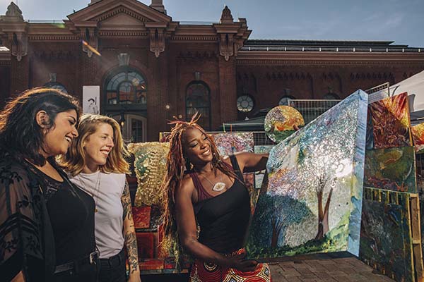 Artist holding painting at market