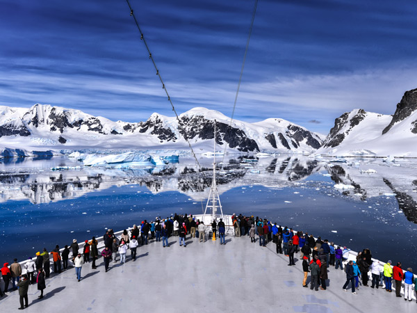 Passengers on the bow of a large cruise ship in Antarctica