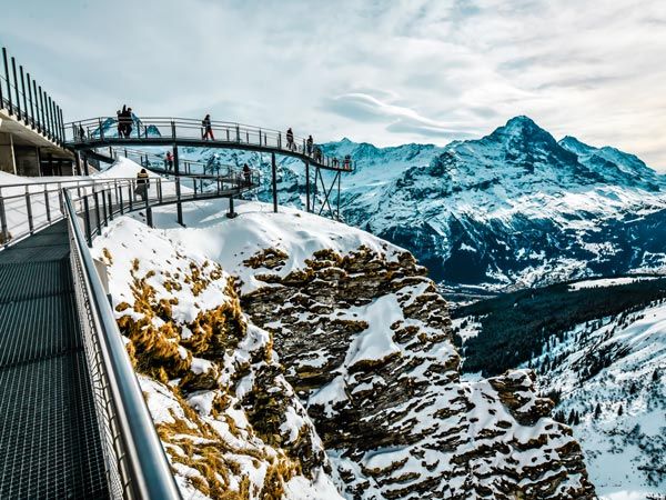People Standing On Cliff Walk, The Famous Walkway Of Grindelwald First, Switzerland