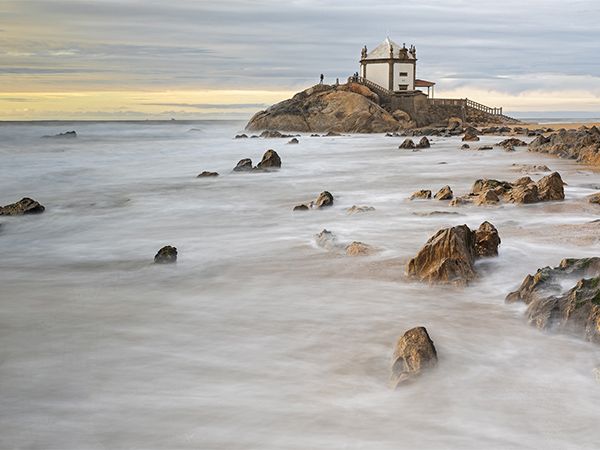 Capela Senhor da Pedra on rugged Miramar beach