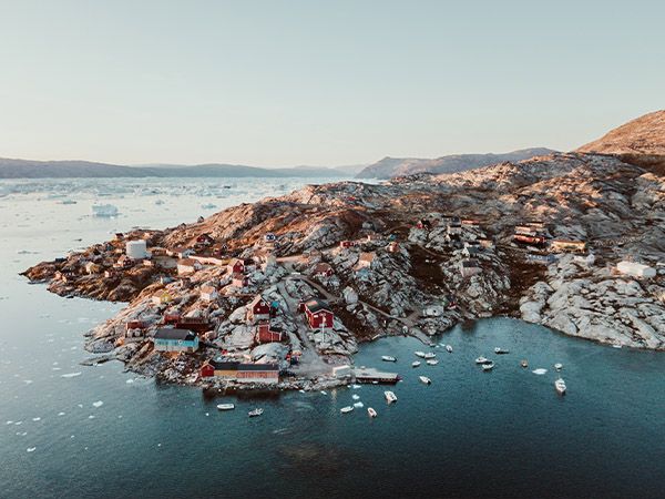 This panorama photo shows a fishing village in the bay of Tasiilaq in East Greenland from above at sunset