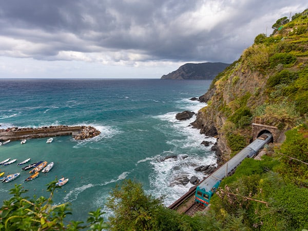 Train passing by boats in the bay at Vernazza, Cinque Terre, Italy