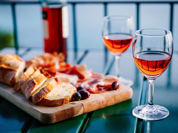 Two glasses of wine and italian snacks with amazing view at sunset in Italy