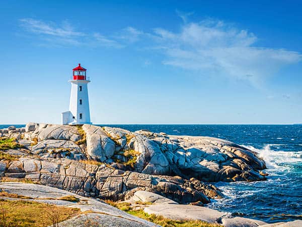 Peggy's Cove Lighthouse under blue summer sky. Peggy's Cove, Nova Scotia, Canada. Day and Night Series.