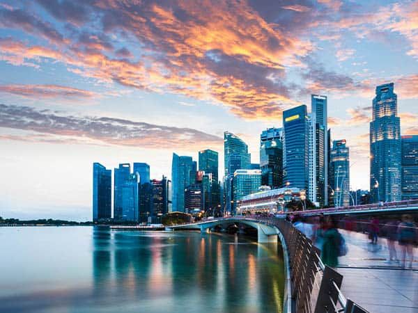Singapore Skyline at Marina Bay at Twilight with glowing sunset illuminating the clouds