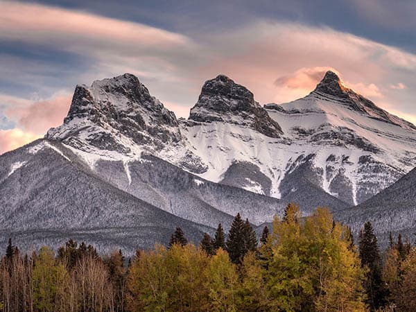 Sunset light just hitting the top of the Three Sister peaks near Canmore, Alberta, Canada
