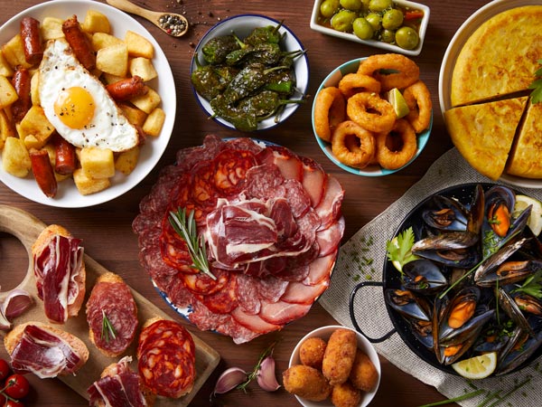 A table with typical Spanish food seen from above on a wooden table