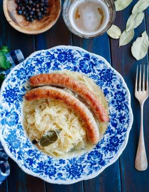 Bratwurst with sauerkraut and beer on blue table