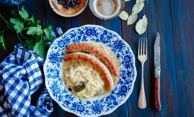 Bratwurst with sauerkraut and beer on blue table