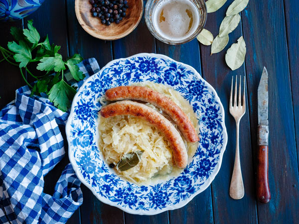Bratwurst with sauerkraut and beer on blue table