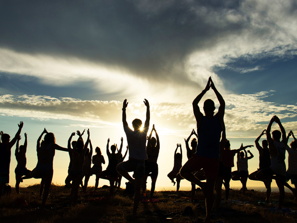 Costa Rica Silhouettes of people doing yoga on the beach at sunset