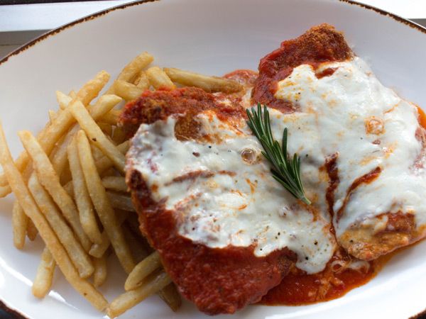 A chicken parmigiana with chips.