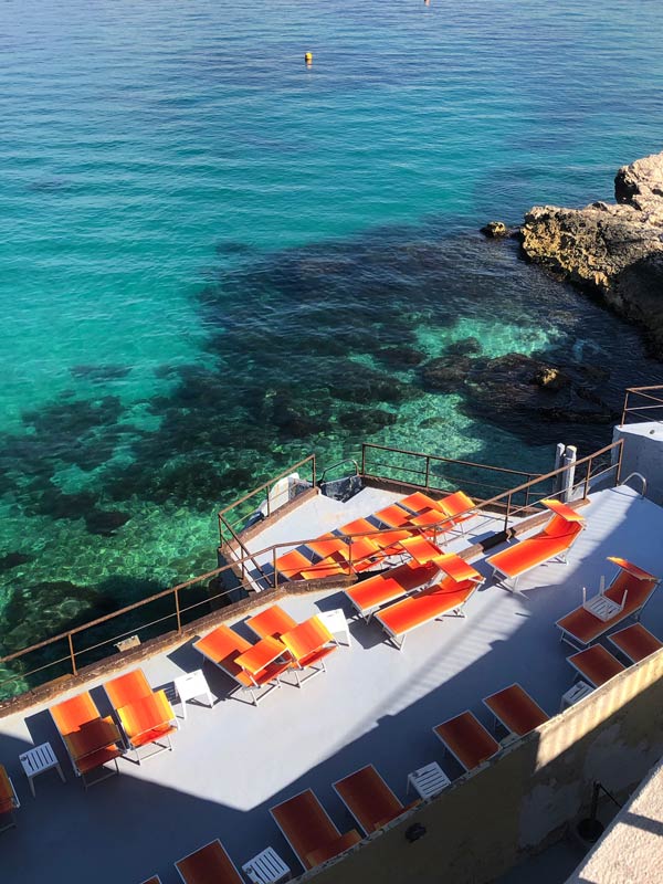 Bright-colored daybeds in beach bars along the Corniche