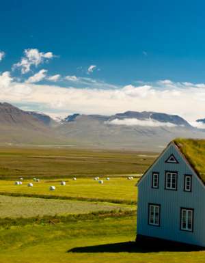 Old farm with mossy roof and typical Icelandic landscape