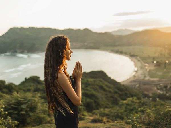 woman meditating on top of the mountain