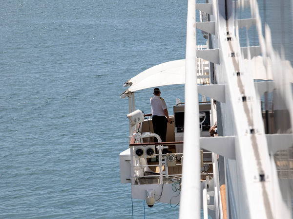 the ship's captain standing and looking at the sea