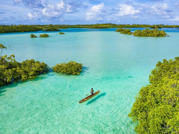 a man standing on a dugout canoe, Santa Isobel, Solomon Islands