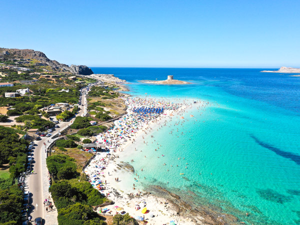 aerial shot of a white-sand beach in Sardinia filled with tourists