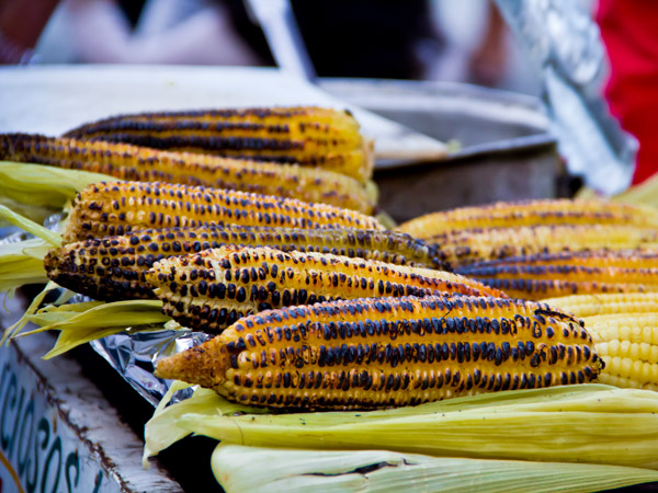 a roasted corn cob in a market stall in Mexico