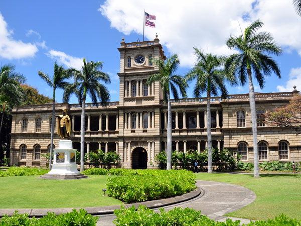 the exterior of Ali'iolani Hale Palace surrounded by palm trees