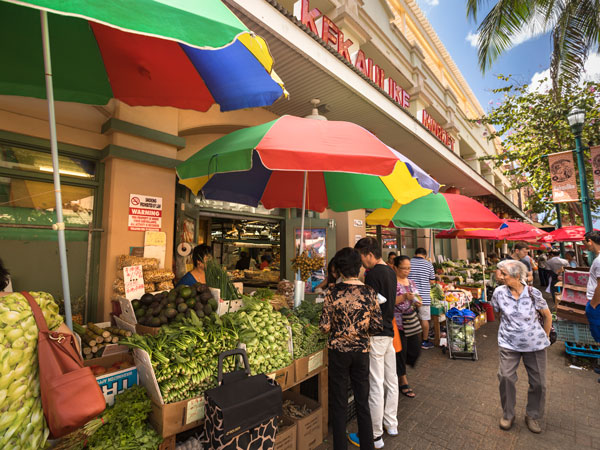 people buying at the stalls along the Chinatown market district in Honolulu