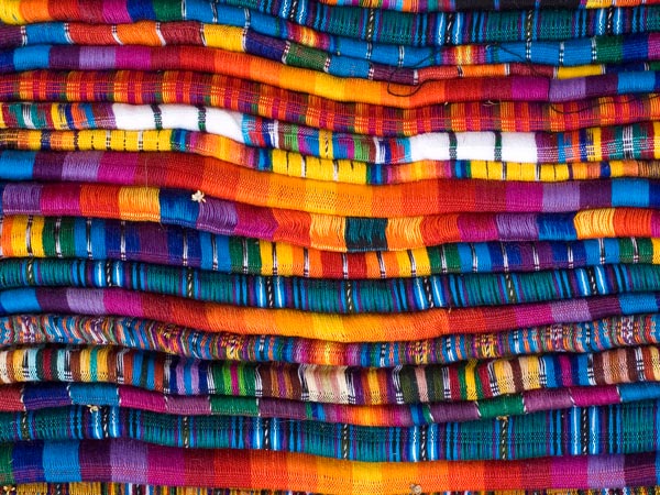 a stack of colourful Mayan blankets