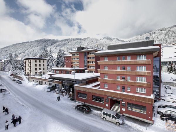  a view of Hotel Grischa with snow-capped mountains as the backdrop