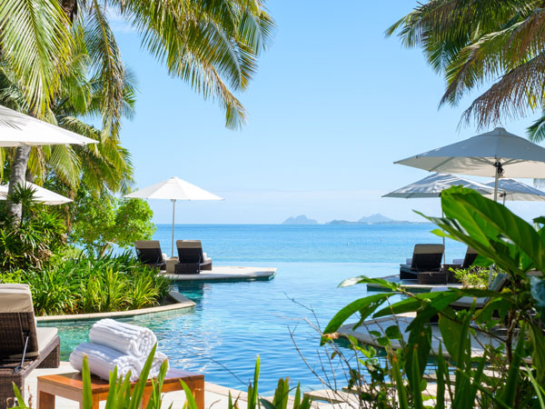 an infinity pool with umbrellas in Likuliku Lagoon Resort