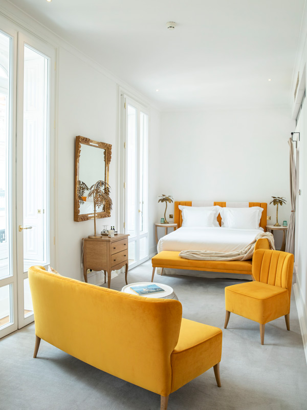 elegant hotel interior with yellow sofas and bed