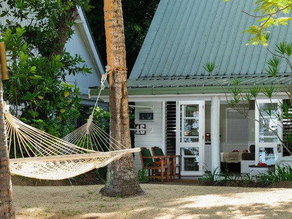 a hammock tied to a palm tree outside an oceanview bure at Malolo Resort