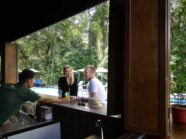 a couple ordering drinks at the pool bar, Sukau Rainforest Lodge
