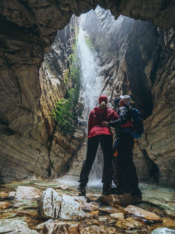 Couple stand inside the marble caves of Trollkyrkja