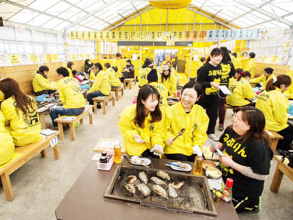 guests dressed in yellow chitchatting inside an oyster hut in Fukuoka