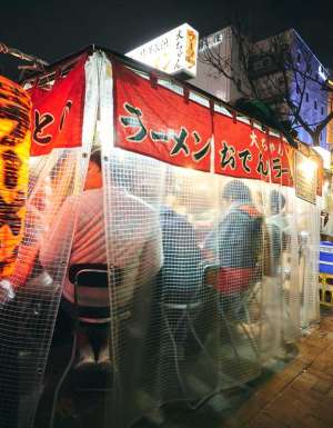 customers dining behind the curtains inside a Yatai food stall along Fukuoka