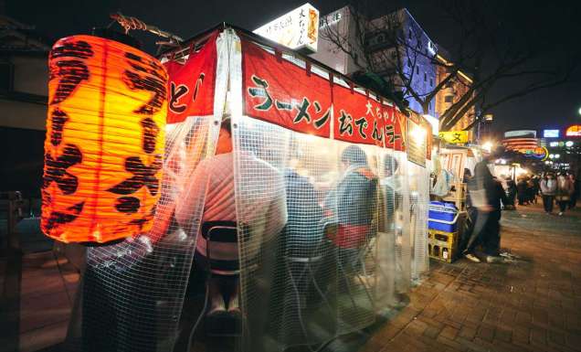 customers dining behind the curtains inside a Yatai food stall along Fukuoka
