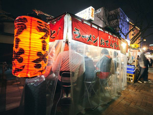 a vibrant Yatai food stall filled with customers