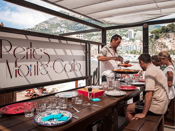 a waiter serving seafood to guests at Les Perles de Monte-Carlo