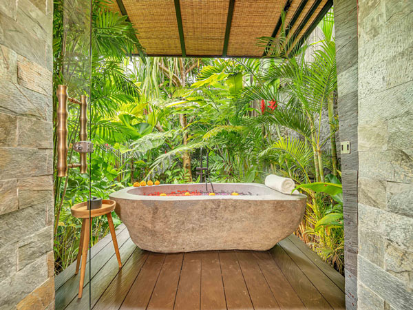 a bathtub with jungle views at Desa Hay sustainable hotel in Bali