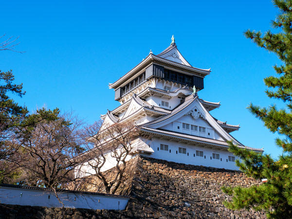the exterior of Kokura Castle with cherry blossom trees in the background