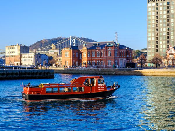 a boat cruising along the river near Mojiko Station at Kitakyushu