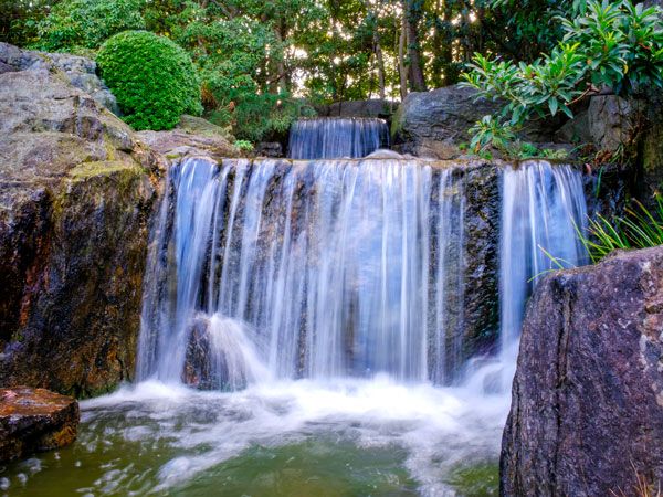a waterfall splashing gently into the stream at Ohori Park Japanese Garden