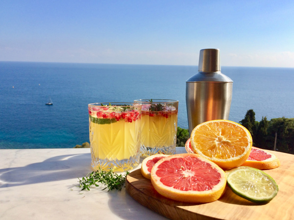a photo of citrus liqueur with a backdrop of the sea at La Distillerie de Monaco